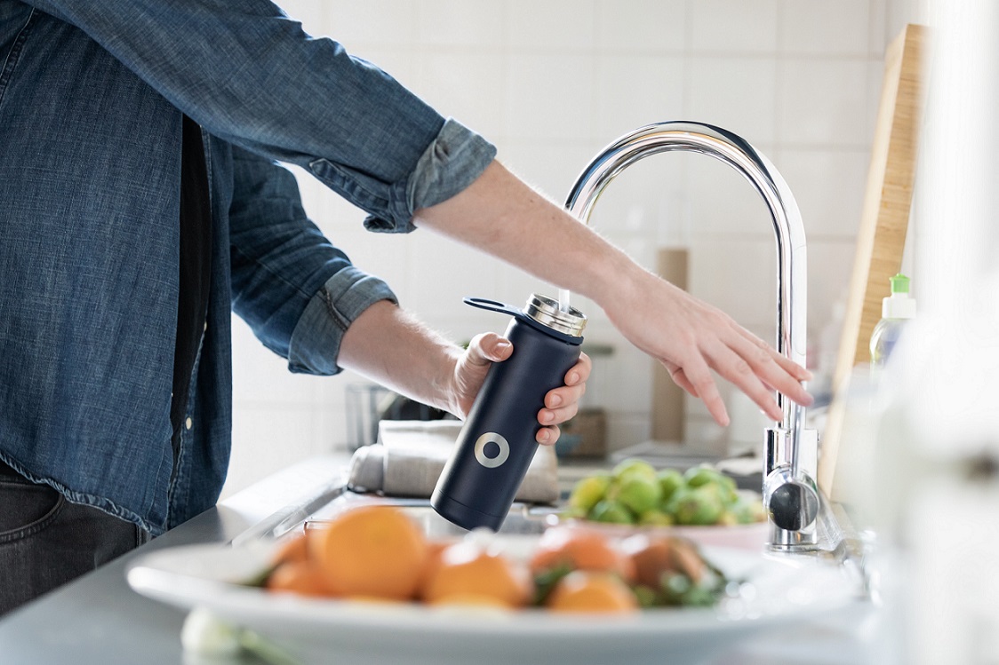 Person filling water bottle at sink