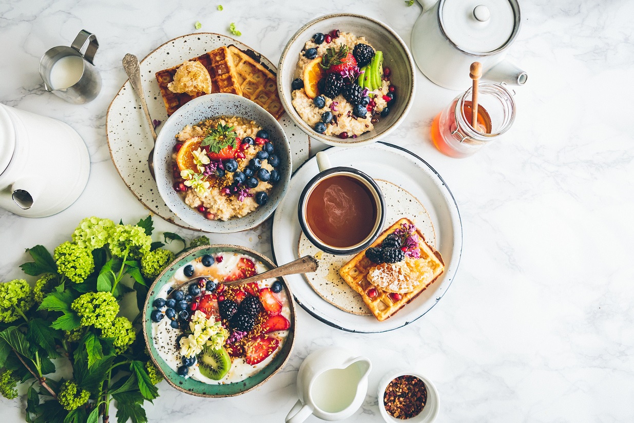 Many food items on white table and plates