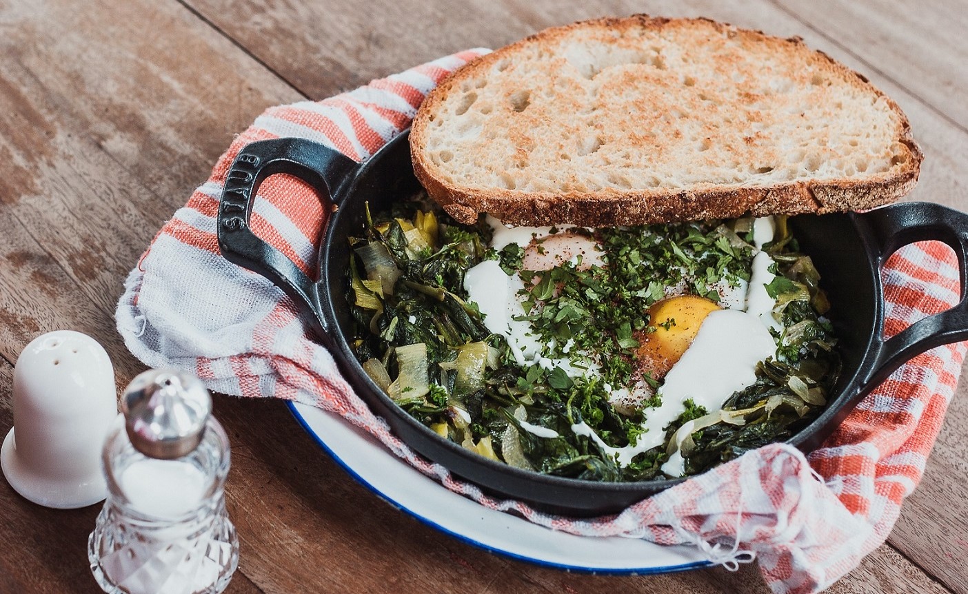 Eggs, greens and toast in cast iron skillet