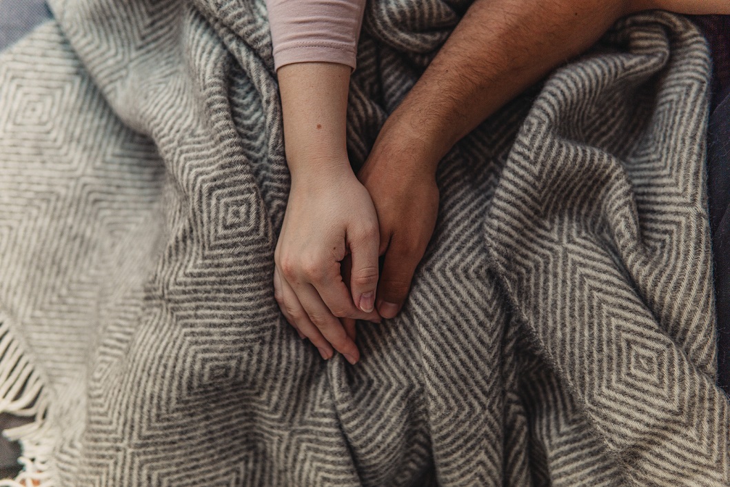 Two hands on top of a blanket