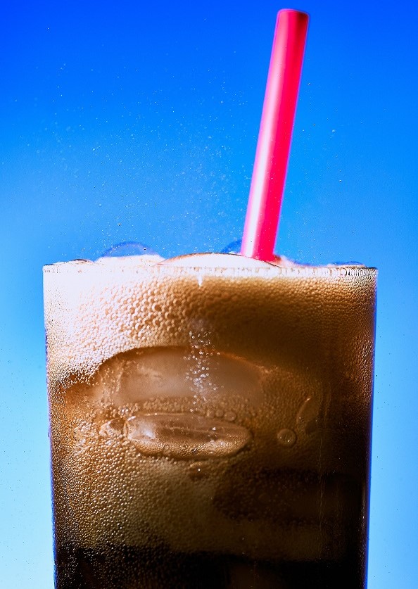 Glass of cola with ice and straw