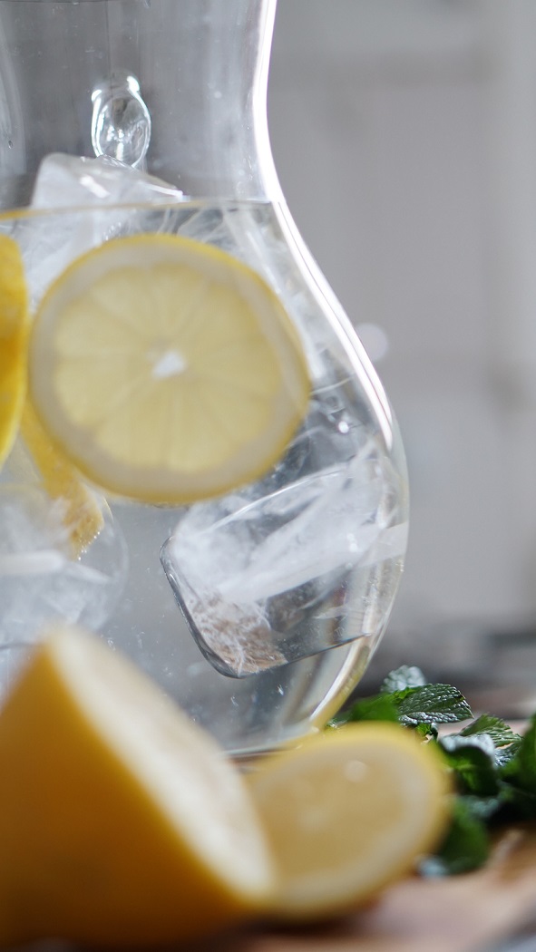 lemon and water in clear pitcher and glass