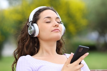 Woman meditating and listening to music