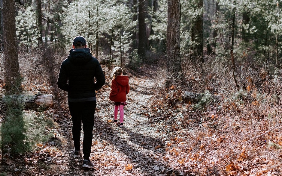 Child and adult walking through woods